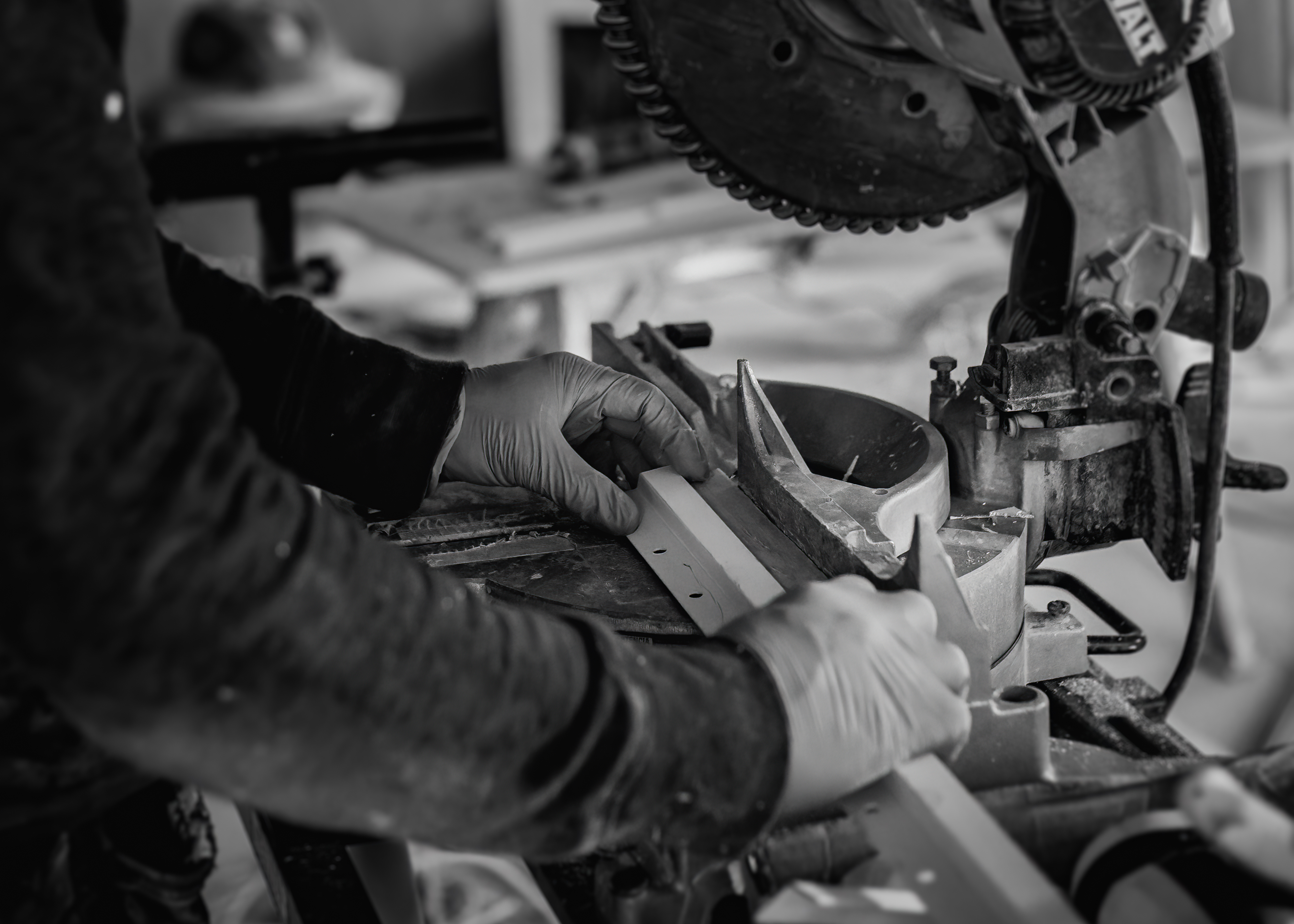 Close view of a craftsperson positioning trim at a miter saw