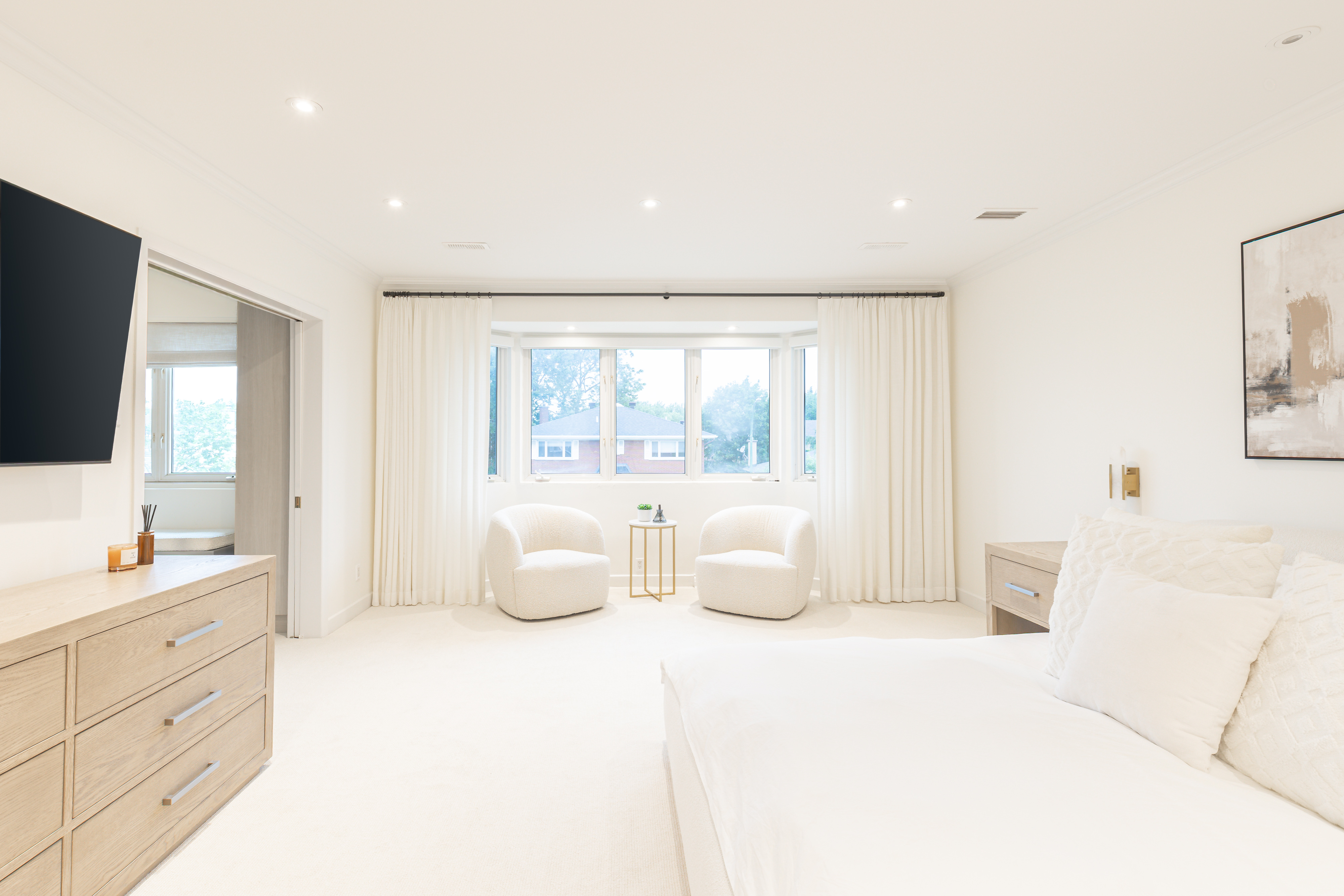 Bright luxury bedroom with a bay-window seating area